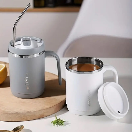 Two coffee cups with lids and straws on a wooden coaster and white surface.