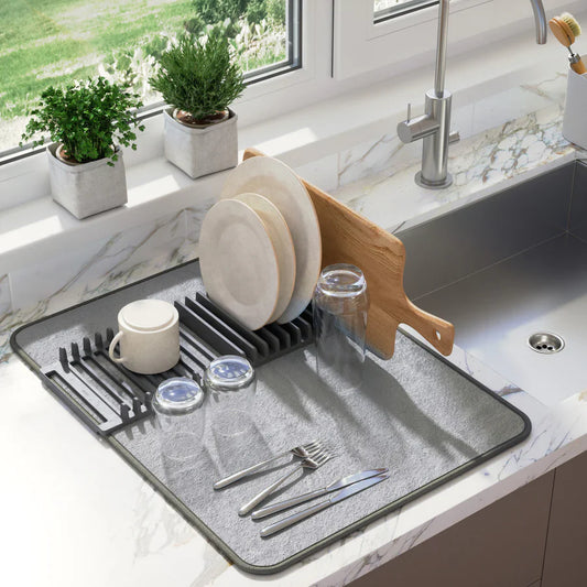 Dish drying rack with dishes on a kitchen counter next to a sink.